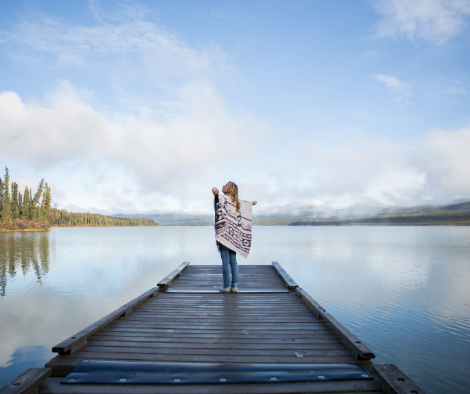 Woman standing on a pier on a lake